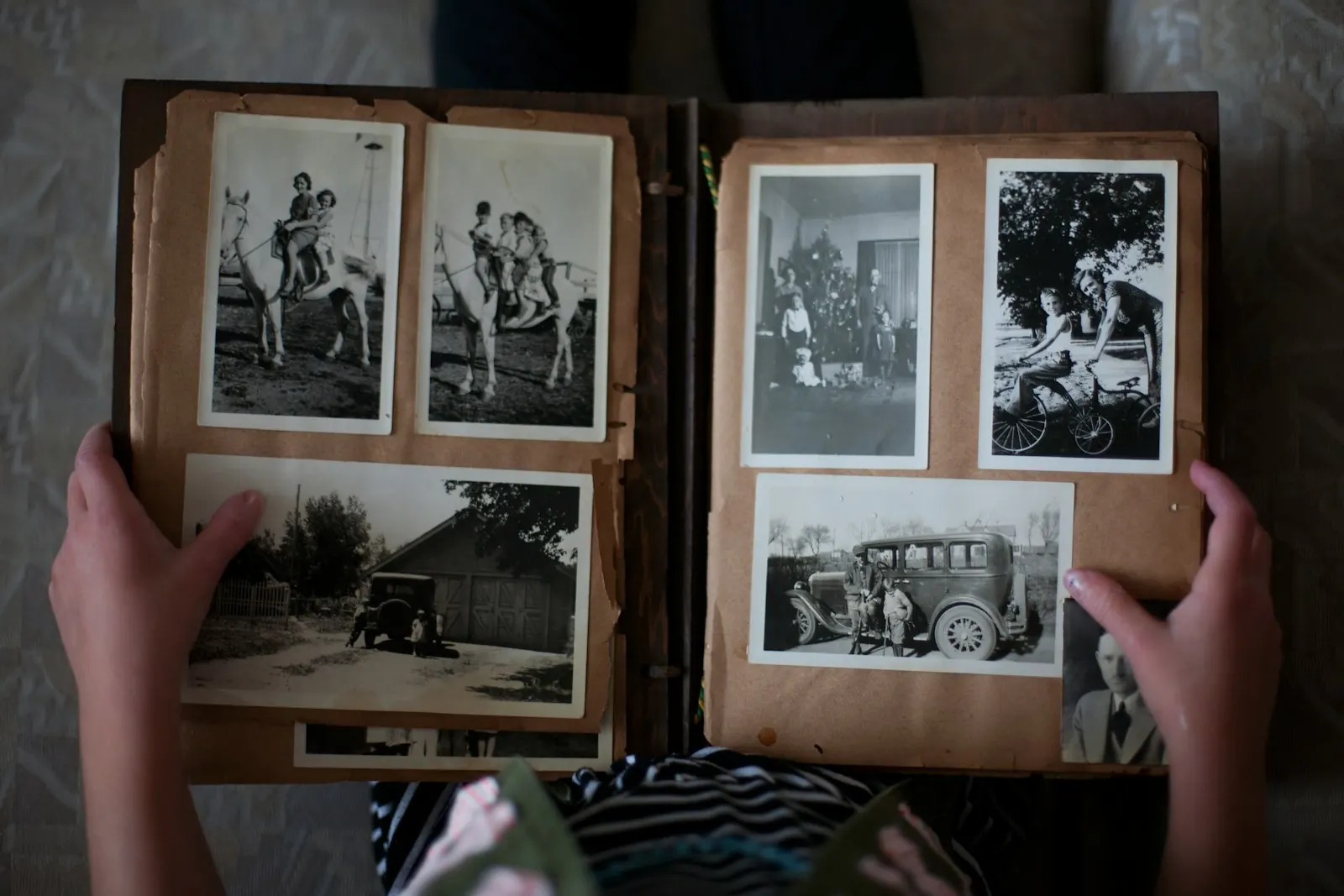 Hands turning the pages of an old family photo album.