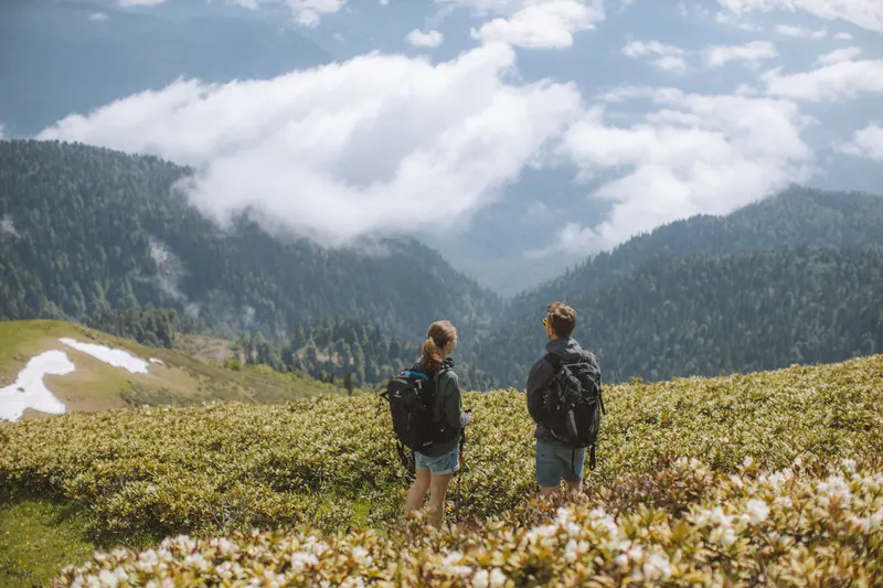 Two hikers on a ridge above a valley filled with clouds