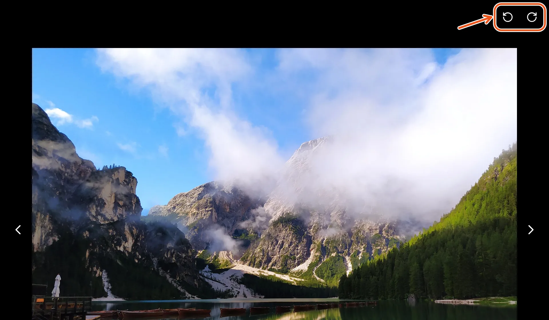 A photo open in the viewer, with the two rotate arrows at its top right marked.